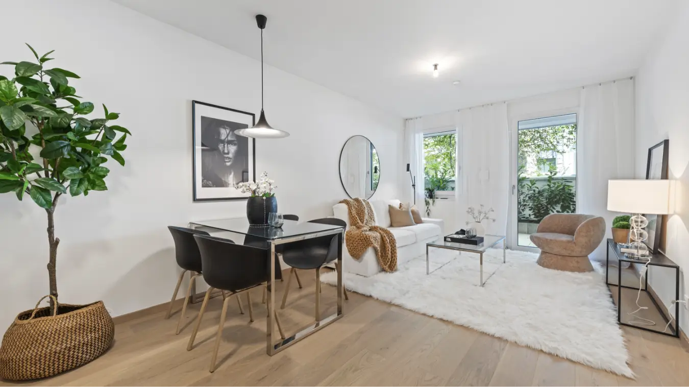 Moderner, heller Wohn- und Essbereich mit Holzboden und Balkon.