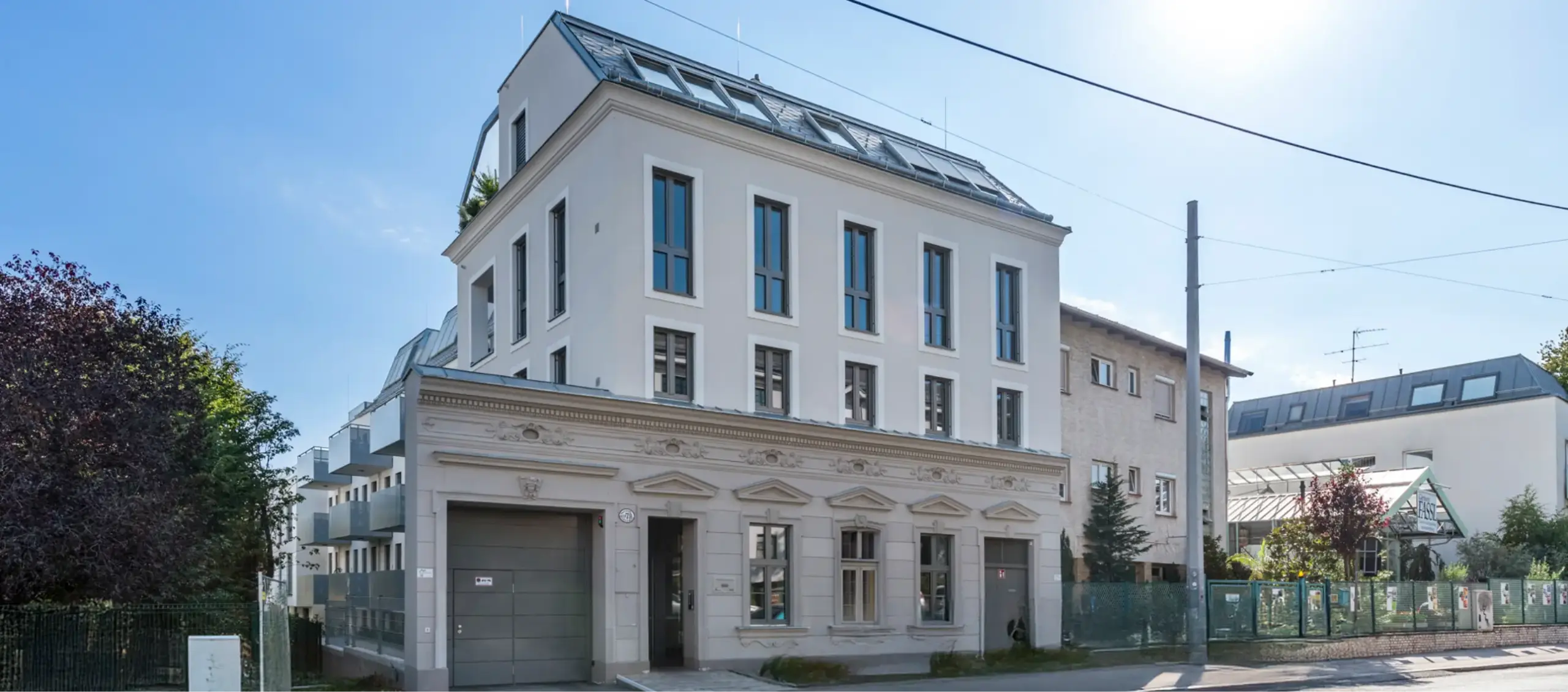 Modernes Mehrfamilienhaus mit schmalen Fenstern und Dachterrassen.